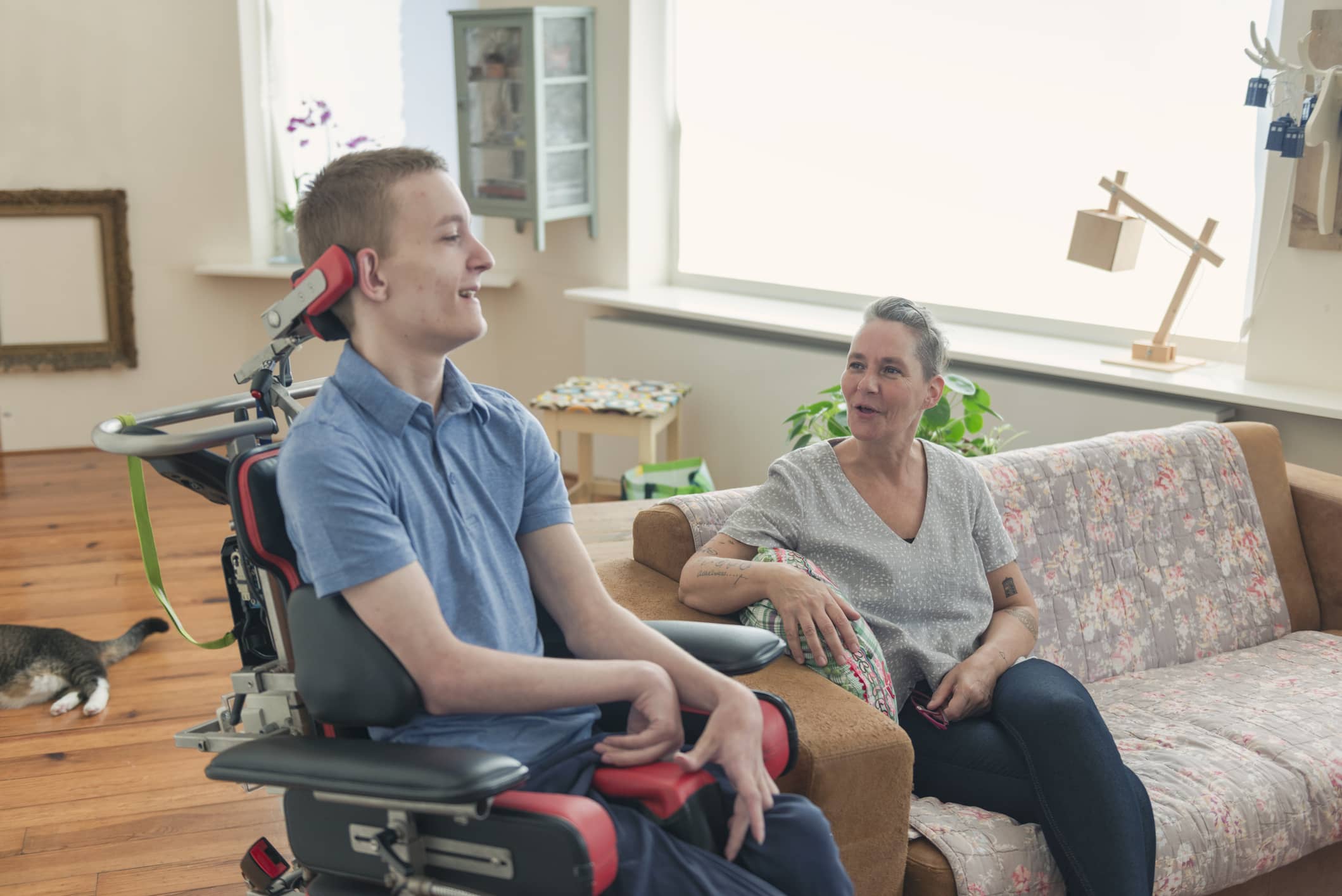 Caregiver and client sit at a kitchen table and at a newspaper
